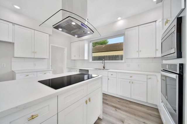 7607 Bankside Dr, Houston, TX 77071 - kitchen with stainless steel appliances, a sink, white cabinets, tasteful backsplash, and light countertops