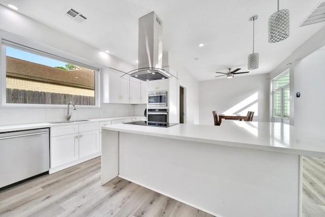 7607 Bankside Dr, Houston, TX 77071 - kitchen featuring appliances with stainless steel finishes, island range hood, a sink, white cabinetry, and recessed lighting