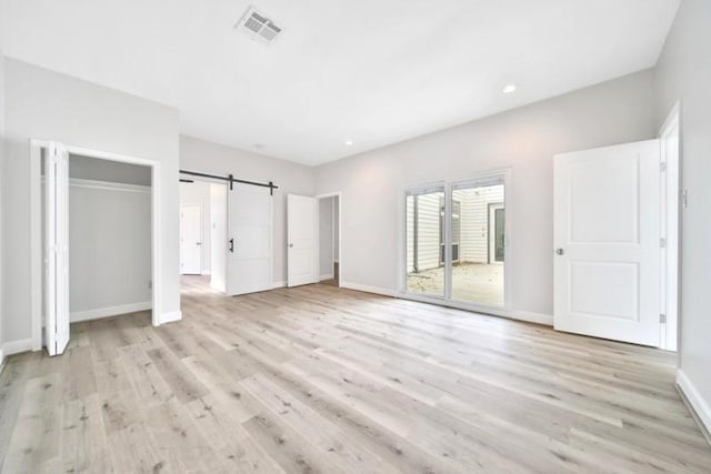 7607 Bankside Dr, Houston, TX 77071 - unfurnished bedroom featuring light wood finished floors, a barn door, baseboards, and recessed lighting