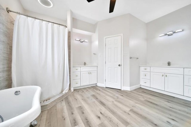 7607 Bankside Dr, Houston, TX 77071 - full bathroom with vanity, ceiling fan, wood finished floors, a soaking tub, and a shower with shower curtain
