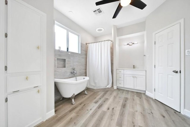 7607 Bankside Dr, Houston, TX 77071 - full bath featuring ceiling fan, wood finished floors, curtained shower, a freestanding bath, and vanity
