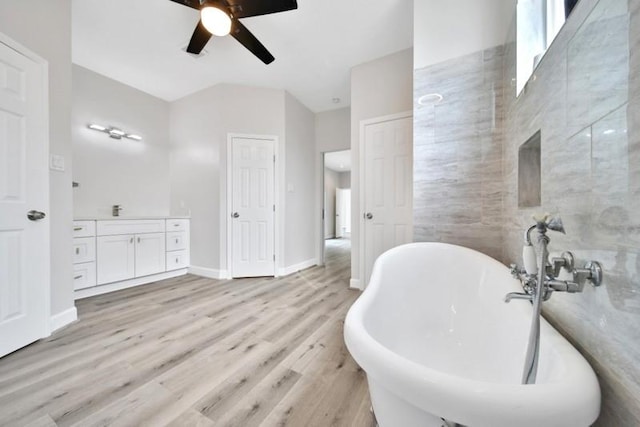 7607 Bankside Dr, Houston, TX 77071 - full bathroom with a soaking tub, a ceiling fan, vanity, wood finished floors, and baseboards
