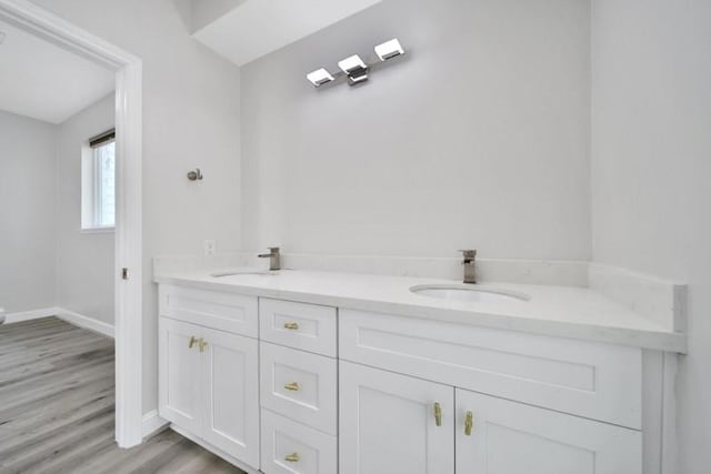 7607 Bankside Dr, Houston, TX 77071 - full bath with baseboards, wood finished floors, double vanity, and toilet