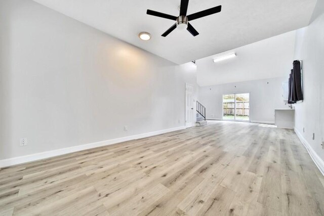 7607 Bankside Dr, Houston, TX 77071 - unfurnished living room with baseboards, light wood-style flooring, ceiling fan, and high vaulted ceiling