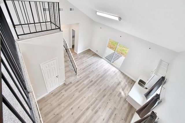 7607 Bankside Dr, Houston, TX 77071 - unfurnished living room with lofted ceiling, wood finished floors, baseboards, and stairs