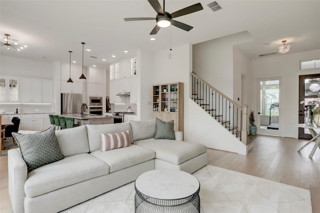 3124 Somerset Levens Ln, Houston, TX 77055 - living area with a towering ceiling, stairs, ceiling fan, recessed lighting, and light wood-style flooring
