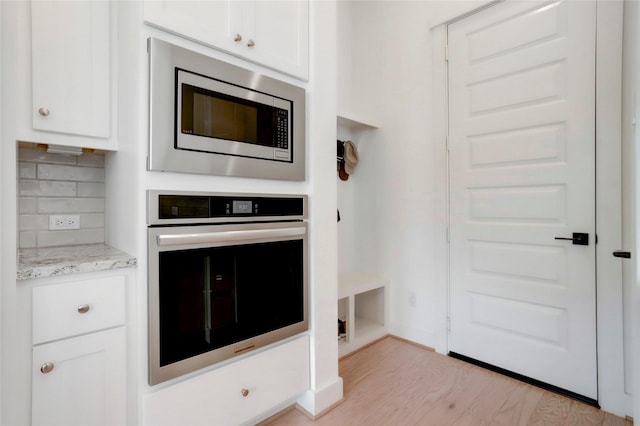 3124 Somerset Levens Ln, Houston, TX 77055 - kitchen with appliances with stainless steel finishes, white cabinets, light wood-style floors, and light stone countertops