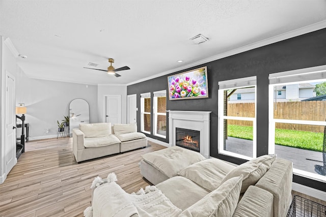 5702 W Vistaglen Loop, Houston, TX 77084 - living area featuring ornamental molding, light wood finished floors, a glass covered fireplace, a ceiling fan, and baseboards