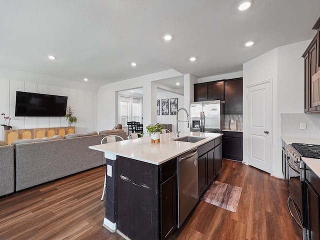 18925 Lazzaro Springs Dr, New Caney, TX 77357 - kitchen featuring stainless steel appliances, a sink, open floor plan, dark wood-type flooring, and recessed lighting