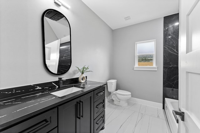 7926 Tate St, Houston, TX 77028 - bathroom with marble look tiles, toilet, vanity, and baseboards