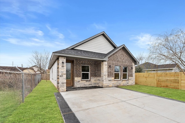 7926 Tate St, Houston, TX 77028 - rear view of house featuring roof with shingles, a patio area, brick siding, and stone siding