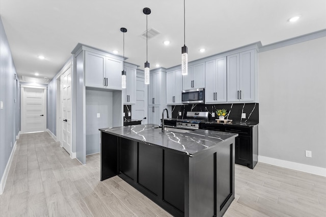 7926 Tate St, Houston, TX 77028 - kitchen featuring appliances with stainless steel finishes, tasteful backsplash, recessed lighting, baseboards, and a kitchen island with sink