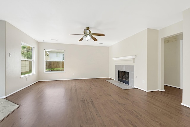 4814 Winding Timbers Ct, Humble, TX 77346 - unfurnished living room featuring ceiling fan, wood finished floors, a tile fireplace, and baseboards