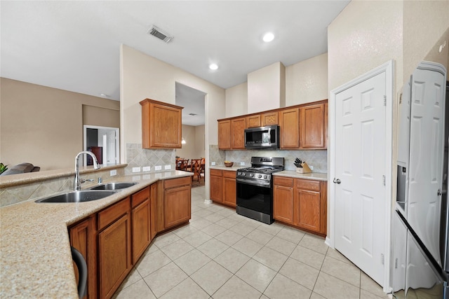 8630 Kirksage Dr, Houston, TX 77089 - kitchen featuring appliances with stainless steel finishes, a sink, tasteful backsplash, and brown cabinetry