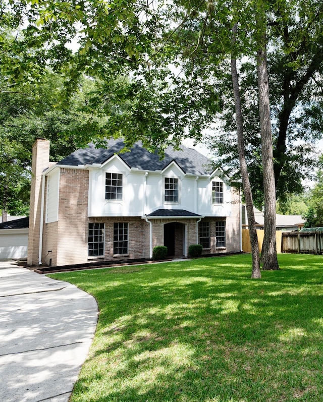 25014 Rettendon Ct, Spring, TX 77389 - view of front facade with brick siding, a chimney, roof with shingles, and an outdoor structure