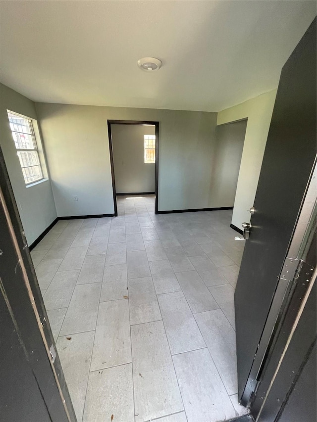 745 Yorkshire St, Houston, TX 77022 - empty room with healthy amount of natural light, light tile patterned floors, and baseboards