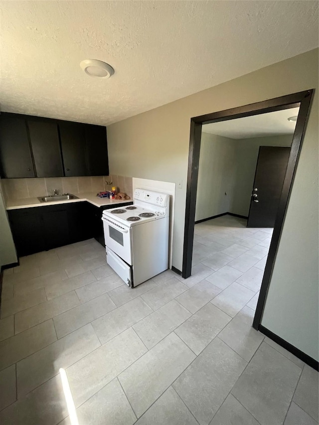 745 Yorkshire St, Houston, TX 77022 - kitchen with white range with electric stovetop, decorative backsplash, light countertops, dark cabinets, and a sink