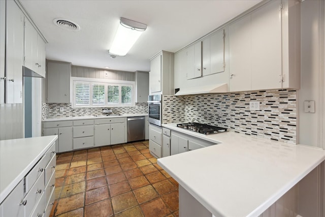 7222 Hartland Ave, Houston, TX 77055 - kitchen with appliances with stainless steel finishes, light countertops, backsplash, a peninsula, and under cabinet range hood