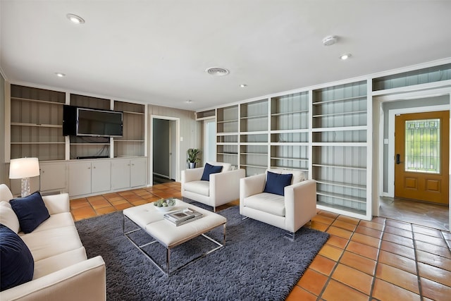 7222 Hartland Ave, Houston, TX 77055 - living room featuring light tile patterned floors, built in shelves, and recessed lighting