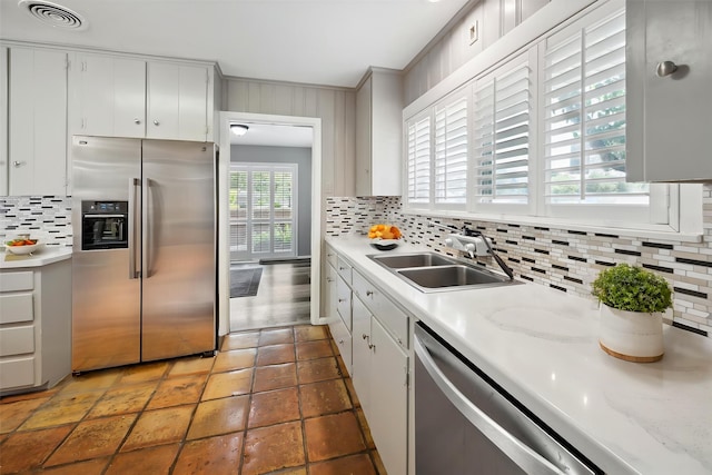 7222 Hartland Ave, Houston, TX 77055 - kitchen with appliances with stainless steel finishes, a sink, decorative backsplash, light countertops, and ornamental molding