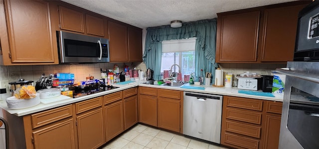 15459 Runswick Dr, Houston, TX 77062 - kitchen featuring appliances with stainless steel finishes, a sink, light countertops, and a textured ceiling