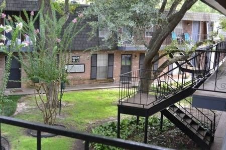 9005 Gaylord St Unit 20, Houston, TX 77024 - exterior space with stairs, brick siding, and a front lawn