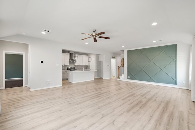 unfurnished living room featuring baseboards, ceiling fan, lofted ceiling, light wood-style flooring, and recessed lighting