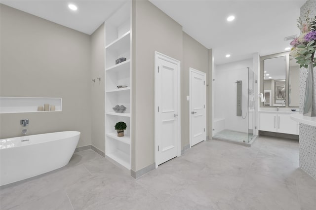 bathroom featuring a stall shower, a freestanding tub, vanity, recessed lighting, and baseboards