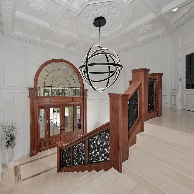 stairway with a decorative wall, coffered ceiling, inlaid floor details, and beam ceiling