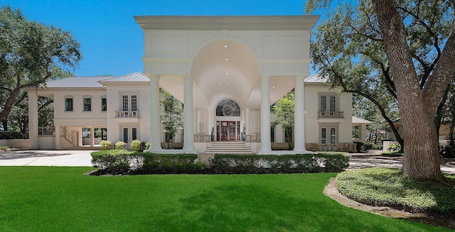 back of house featuring french doors, a carport, a yard, and stucco siding