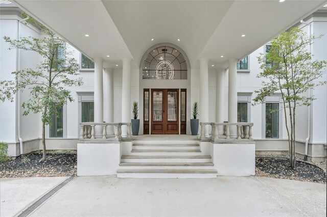 doorway to property with french doors, stucco siding, and a porch