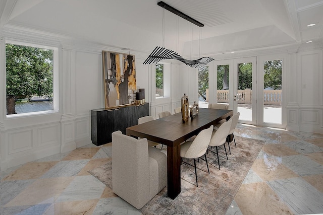 dining space with a decorative wall, french doors, recessed lighting, and a tray ceiling