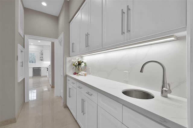 washroom with a sink, baseboards, and recessed lighting