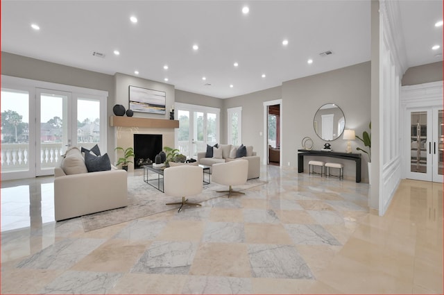 living area with marble tiled flooring, recessed lighting, french doors, and a fireplace