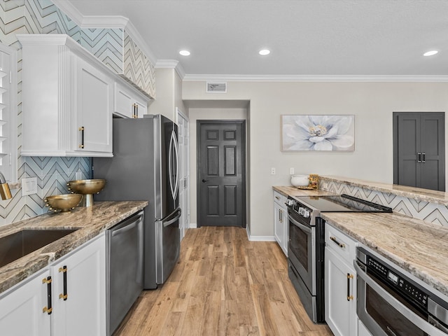 441 Jeanie Lynn St, Galveston, TX 77554 - kitchen featuring appliances with stainless steel finishes, crown molding, tasteful backsplash, light stone counters, and white cabinets
