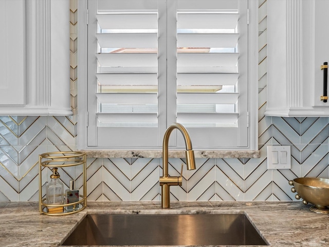 441 Jeanie Lynn St, Galveston, TX 77554 - kitchen view of a sink, white cabinets, and light stone countertops