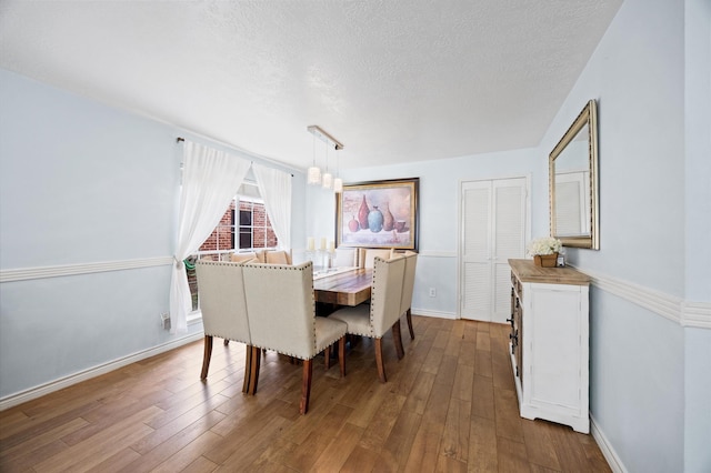 9519 Territory Ln, Houston, TX 77064 - dining area featuring a textured ceiling, hardwood / wood-style flooring, and baseboards