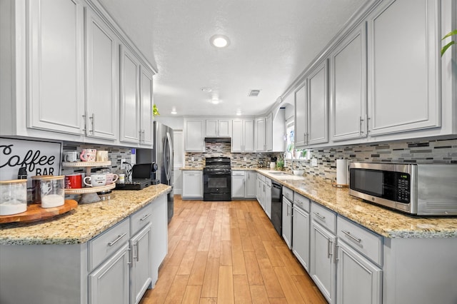 9519 Territory Ln, Houston, TX 77064 - kitchen featuring black appliances, gray cabinetry, a sink, light wood-style floors, and recessed lighting