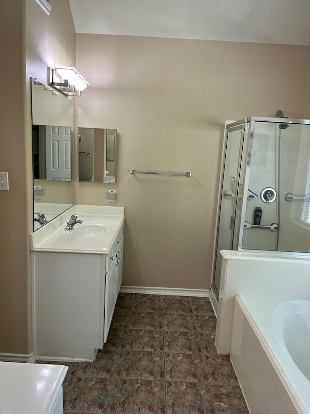 bathroom featuring a shower stall, vanity, baseboards, and a garden tub