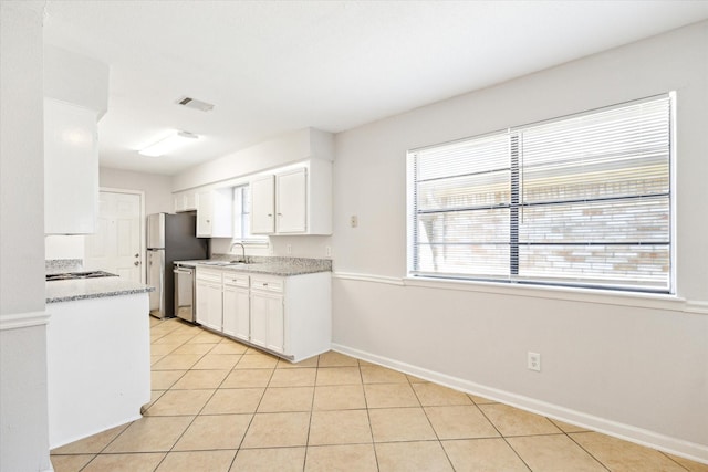 5519 Fallengate Dr, Spring, TX 77373 - kitchen featuring a sink, stainless steel appliances, white cabinets, baseboards, and light tile patterned floors