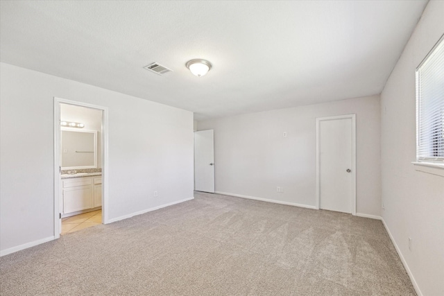 5519 Fallengate Dr, Spring, TX 77373 - unfurnished bedroom with light carpet, ensuite bathroom, and baseboards