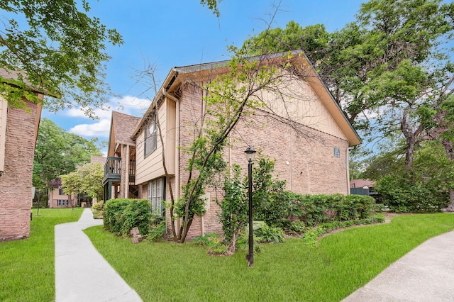 8229 Kingsbrook Rd Unit 229, Houston, TX 77024 - view of property exterior with a lawn, brick siding, and a balcony