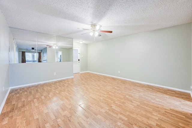 8229 Kingsbrook Rd Unit 229, Houston, TX 77024 - empty room featuring a ceiling fan, light wood-type flooring, a textured ceiling, and baseboards