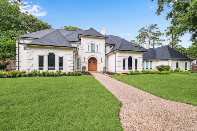 2203 Long Valley Dr, Kingwood, TX 77345 - french country inspired facade featuring a chimney, a front yard, and roof with shingles