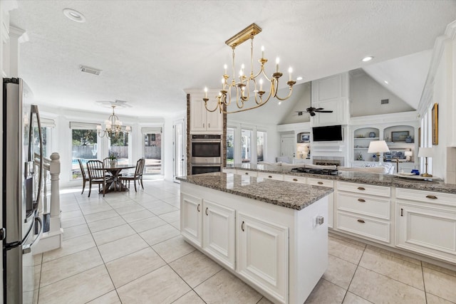 2203 Long Valley Dr, Kingwood, TX 77345 - kitchen with a chandelier, appliances with stainless steel finishes, a textured ceiling, a kitchen island, and a ceiling fan