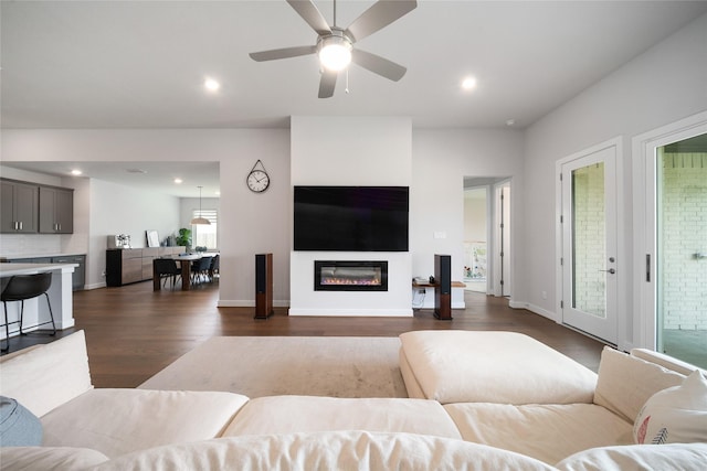 1682 Sherwood Glen Dr, Friendswood, TX 77546 - living area with dark wood-type flooring, a glass covered fireplace, recessed lighting, a ceiling fan, and baseboards