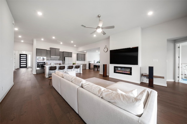 1682 Sherwood Glen Dr, Friendswood, TX 77546 - living area featuring a ceiling fan, dark wood finished floors, recessed lighting, baseboards, and a glass covered fireplace