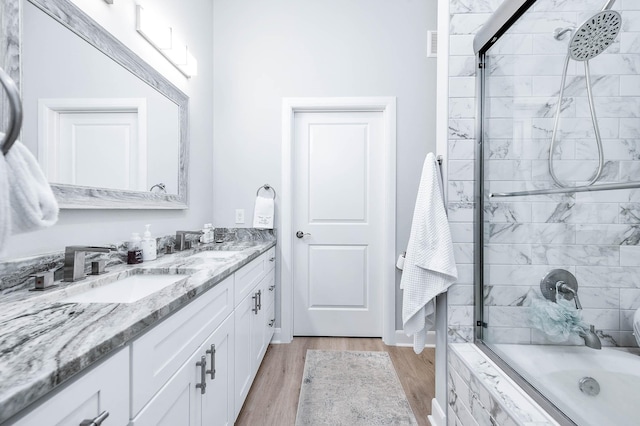 300 St Joseph Pkwy Unit 121, Houston, TX 77002 - bathroom featuring tiled shower / bath combo, double vanity, and wood finished floors
