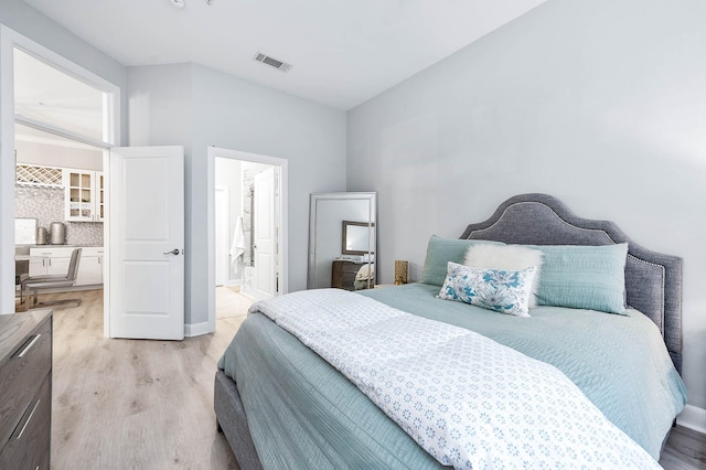 300 St Joseph Pkwy Unit 121, Houston, TX 77002 - bedroom with light wood finished floors, ensuite bathroom, and baseboards