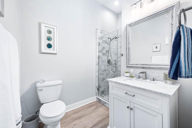 300 St Joseph Pkwy Unit 121, Houston, TX 77002 - bathroom featuring a shower stall, wood finished floors, baseboards, vanity, and toilet